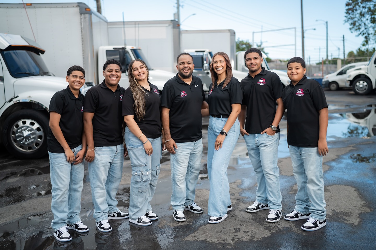 Familia y equipo De La Paz Transport Corp. frente a su flota